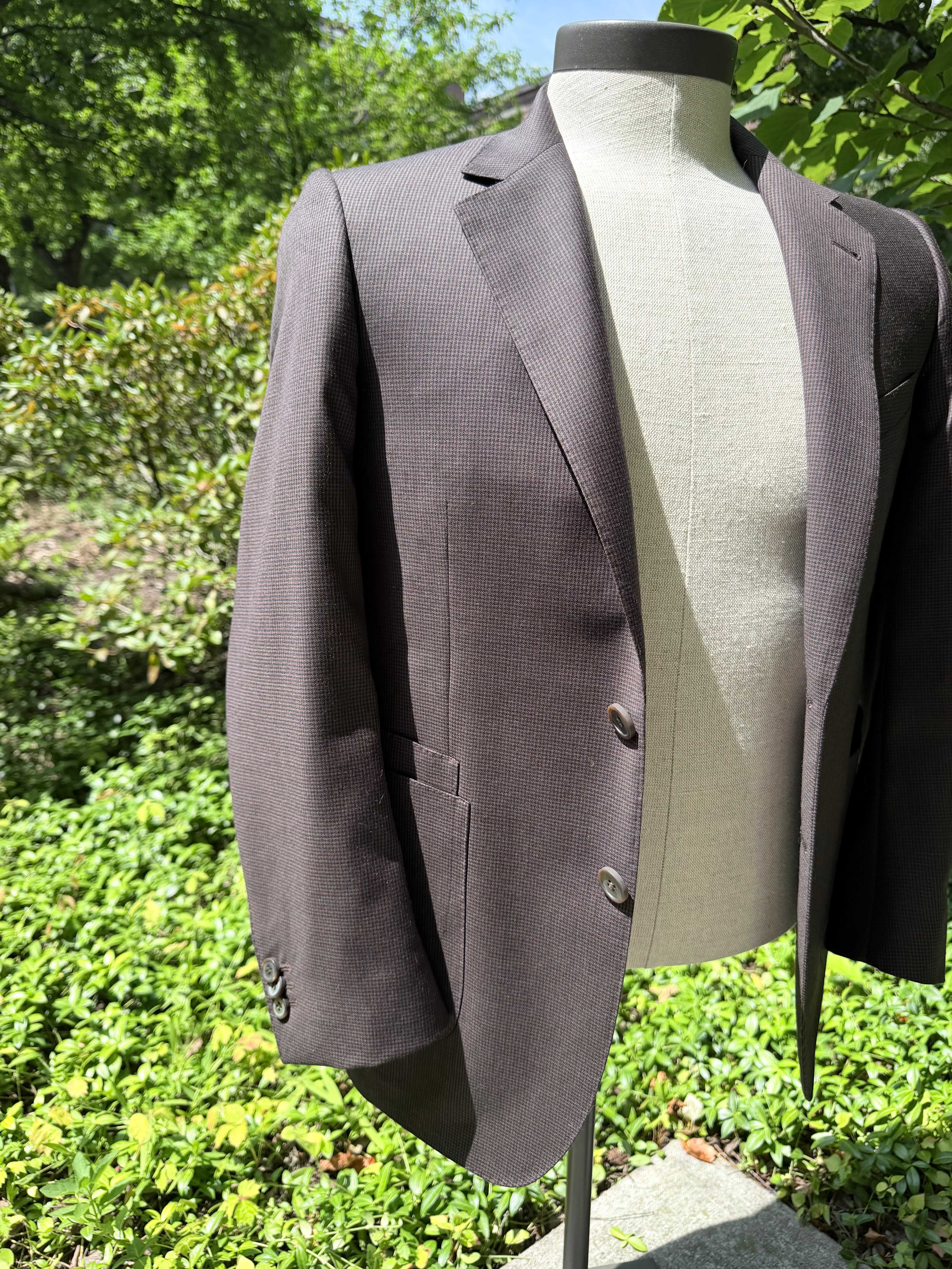 Brown nailhead check tailored jacket at a three-quarter angle