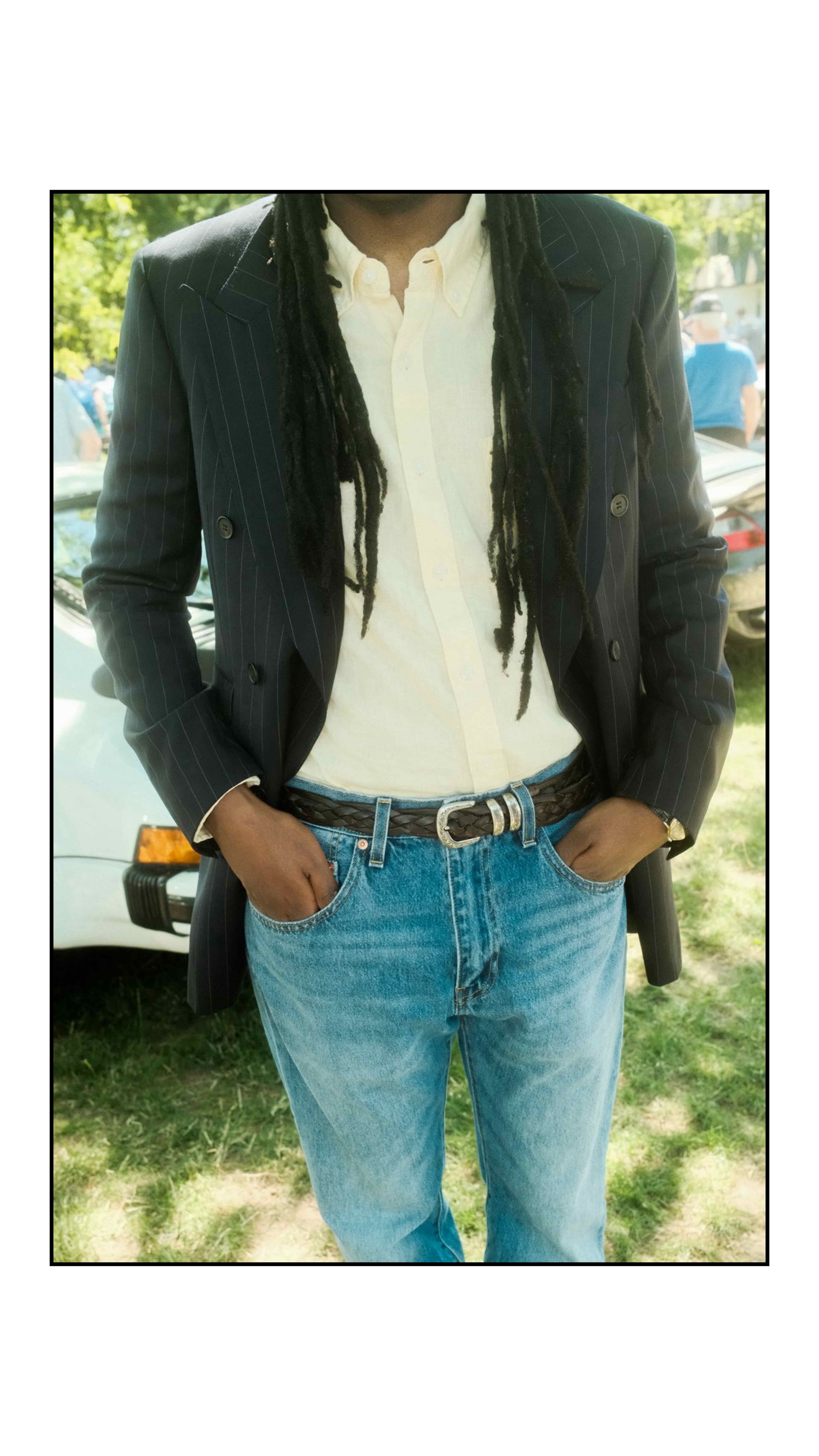 Client wearing a navy pinstripe double-breasted jacket over a cream shirt with denim